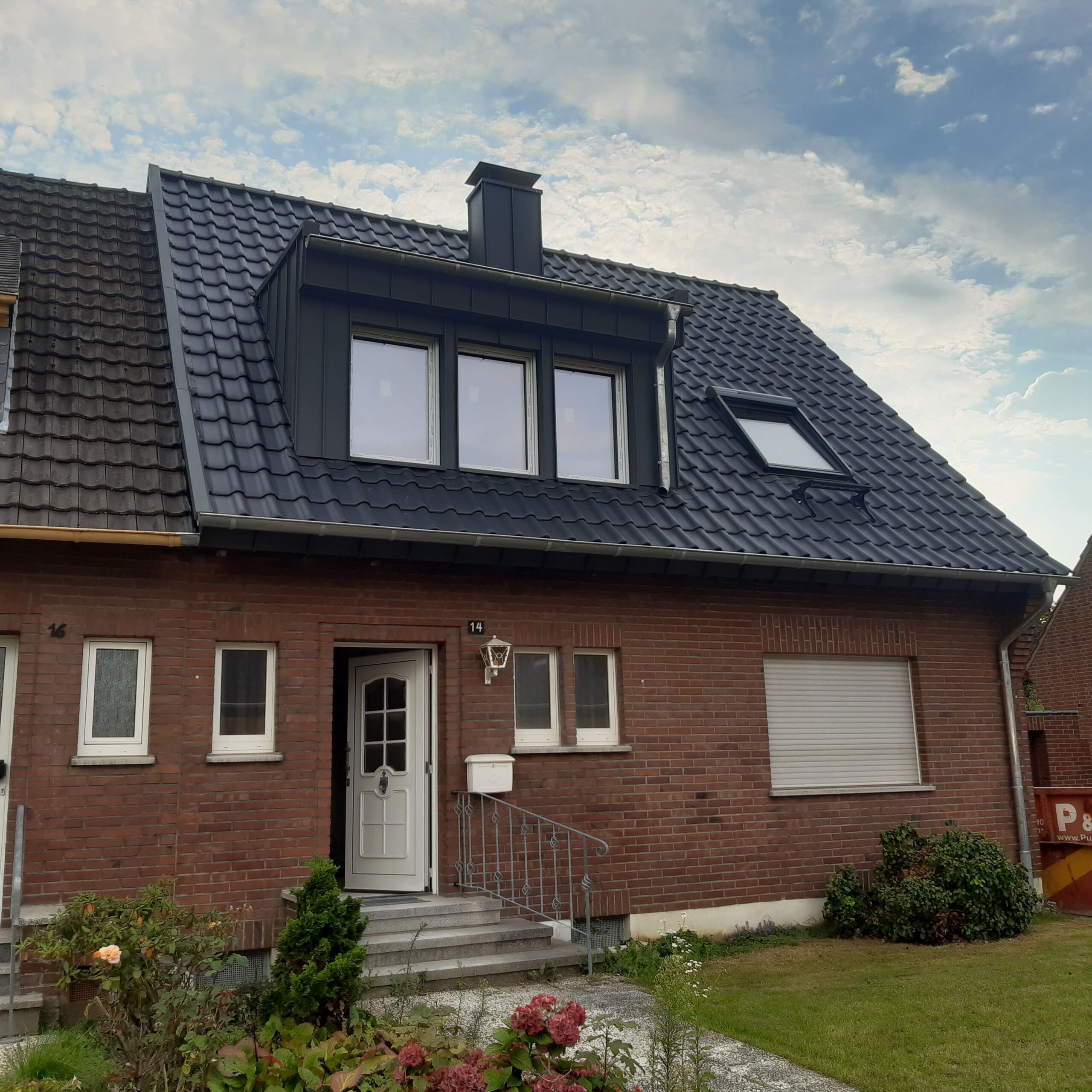 Ein saniertes Steildach mit sanierter Dachgaube, saniertem Kamin und einem VELUX-Dachfenster
